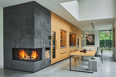 Imagen de cocina contemporánea extra grande con puertas de armario marrones, encimera de piedra caliza, una isla y encimeras grises