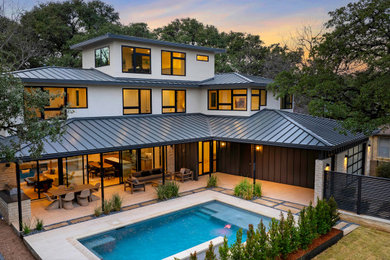 Großes, Dreistöckiges Modernes Einfamilienhaus mit Steinfassade, beiger Fassadenfarbe, Blechdach und braunem Dach in Austin