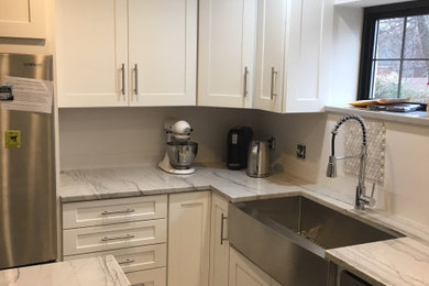 Kitchen - large contemporary u-shaped kitchen idea in St Louis with a farmhouse sink, shaker cabinets, white cabinets, marble countertops, stainless steel appliances, an island and white countertops