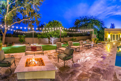 This is an example of an expansive contemporary backyard patio in Phoenix with a fire feature, tile and no cover.