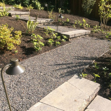 Crushed gravel walkway with paver steps and metal edging.