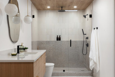 Example of a large 1950s master white tile and ceramic tile terrazzo floor, gray floor, single-sink and wood ceiling bathroom design with flat-panel cabinets, light wood cabinets, a one-piece toilet, white walls, a drop-in sink, a hinged shower door, white countertops and a floating vanity