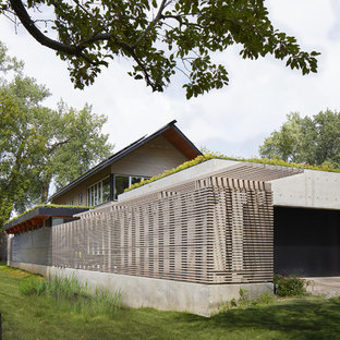 Новый формат декора квартиры: маленький, двухэтажный фасад частного дома серого цвета в современном стиле с комбинированной облицовкой, плоской крышей и зеленой крышей