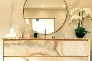 Photo of a large modern bathroom in Sydney with a freestanding tub, an urinal, onyx benchtops and a single vanity.