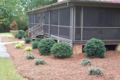 This is an example of a mid-sized traditional full sun front yard mulch formal garden in Other.