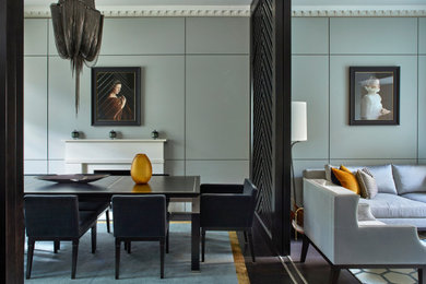 Источник вдохновения для домашнего уюта: столовая в современном стиле с серыми стенами, темным паркетным полом, стандартным камином, коричневым полом и панелями на части стены