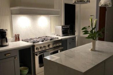 Inspiration for a mid-sized scandinavian galley laminate floor and gray floor eat-in kitchen remodel in Bridgeport with an undermount sink, beaded inset cabinets, gray cabinets, quartzite countertops, white backsplash, stone slab backsplash, stainless steel appliances, an island and white countertops