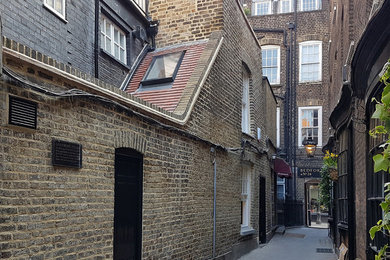 This is an example of a small and yellow victorian two floor brick terraced house in London with a pitched roof and a tiled roof.