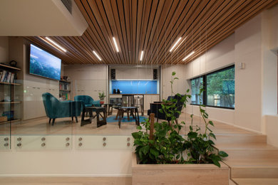 Diseño de despacho nórdico pequeño con paredes beige, suelo de madera clara, escritorio empotrado y machihembrado