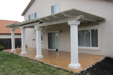 This is an example of a mid-sized transitional backyard deck in Sacramento with a roof extension.