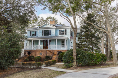 Example of a large classic blue three-story wood house exterior design in Charleston with a hip roof and a shingle roof