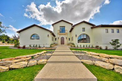 Huge tuscan beige two-story stucco exterior home photo in Austin with a hip roof