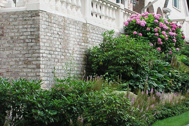 This is an example of a large traditional shade backyard landscaping in New York.