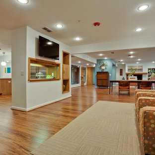 Idées déco pour une salle de cinéma rétro de taille moyenne et ouverte avec un mur blanc, un sol en bambou et un téléviseur fixé au mur.