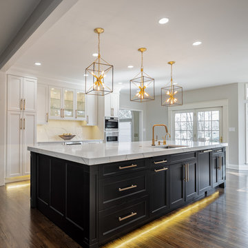 Transitional kitchen with dark and light cabinets and gold accents