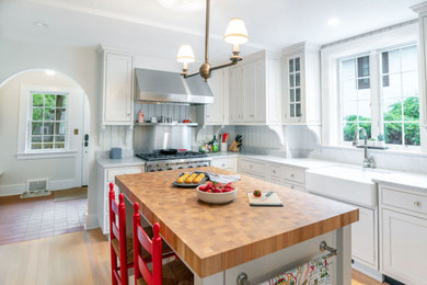 Elegant kitchen photo in Detroit with a farmhouse sink and an island