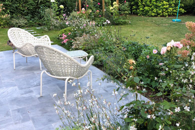 Aménagement d'un jardin de taille moyenne avec un massif de fleurs.