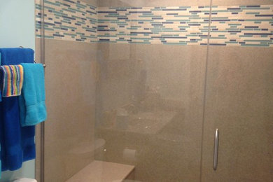 Example of a mid-sized transitional master blue tile and mosaic tile vinyl floor and beige floor alcove shower design in Chicago with a two-piece toilet, blue walls, an integrated sink, onyx countertops and a hinged shower door