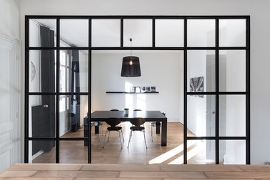 Idée de décoration pour une salle à manger design fermée et de taille moyenne avec un mur blanc, un sol en bois brun et aucune cheminée.