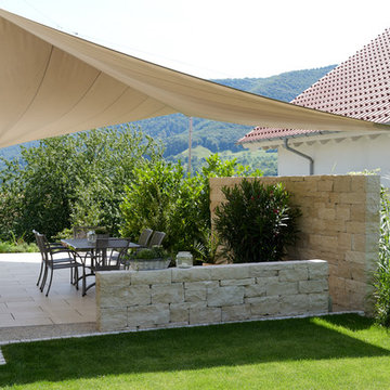 Großzügige Terrasse mit stilvollem Sonnenschutz