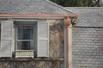 Modelo de fachada de casa de estilo americano con revestimiento de piedra y tejado a cuatro aguas