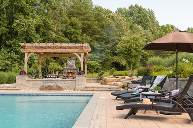 Example of a large mountain style backyard concrete paver patio design in Richmond