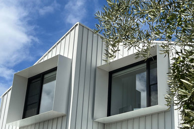Design ideas for a mid-sized contemporary two-storey house exterior in Melbourne with metal siding.