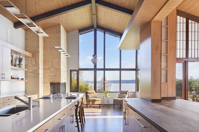Open concept kitchen - large 1950s galley medium tone wood floor and brown floor open concept kitchen idea in Seattle with an undermount sink, flat-panel cabinets, medium tone wood cabinets, quartz countertops and an island