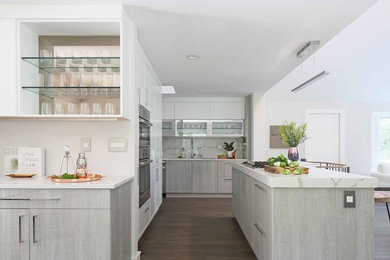 Inspiration for a large modern galley open plan kitchen in New York with an undermount sink, flat-panel cabinets, grey cabinets, quartz benchtops, white splashback, marble splashback, stainless steel appliances, vinyl floors and with island.
