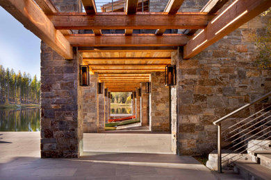 Example of a mountain style stone exterior home design in Other with a mixed material roof