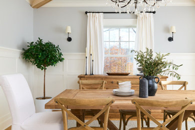 Example of a mountain style light wood floor, exposed beam and wainscoting enclosed dining room design in New York with gray walls