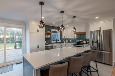 Example of a large trendy l-shaped medium tone wood floor open concept kitchen design in Ottawa with a double-bowl sink, shaker cabinets, white cabinets, quartz countertops, blue backsplash, ceramic backsplash, stainless steel appliances, an island and white countertops