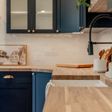 White Farmhouse Sink with Matte Black Pull-Down Faucet and Navy Cabinets