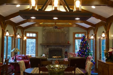 Example of an open concept medium tone wood floor living room design in Other with green walls, a standard fireplace and a media wall