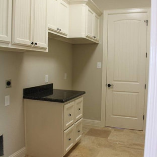 ヒューストンの中サイズのトランジショナルスタイルのおしゃれな家事室 (ドロップインシンク、落し込みパネル扉のキャビネット、白いキャビネット、御影石カウンター、ベージュの壁、トラバーチンの床) の写真