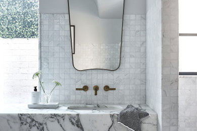 Photo of a mid-sized transitional master bathroom in Sydney with furniture-like cabinets, white cabinets, a freestanding tub, an open shower, a one-piece toilet, beige tile, marble, grey walls, porcelain floors, an undermount sink, marble benchtops, grey floor, an open shower, a laundry, a single vanity and a floating vanity.