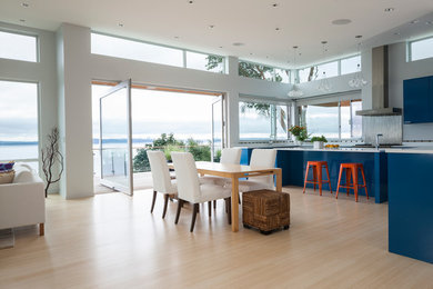 Example of a mid-sized trendy light wood floor and beige floor great room design in Seattle with white walls and no fireplace