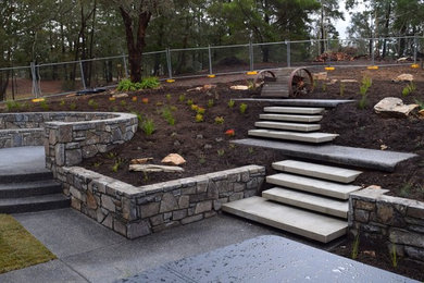Photo of a large contemporary backyard formal garden for winter in Canberra - Queanbeyan with a fire feature and concrete pavers.