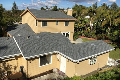Example of a mid-sized classic beige two-story vinyl exterior home design in San Diego with a shingle roof