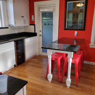 Contemporary Kitchen Remodel With White Cabinets and Black Countertop
