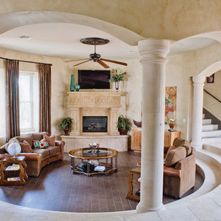 Großes, Offenes Mediterranes Wohnzimmer mit beiger Wandfarbe, Keramikboden, Kamin, Kaminsims aus Stein und Wand-TV in Austin