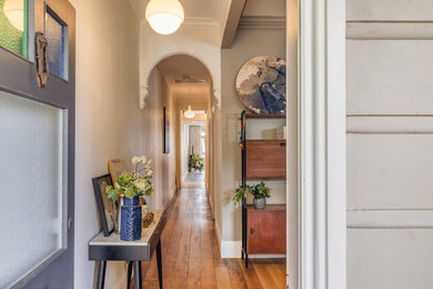 Photo of a midcentury hallway in Sydney with white walls, dark hardwood floors and brown floor.