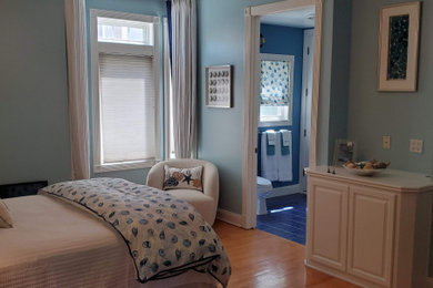 ロサンゼルスにある中くらいなビーチスタイルのおしゃれな客用寝室 (青い壁、淡色無垢フローリング、青い床)