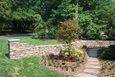 Inspiration for a traditional full sun front yard stone retaining wall landscape in Other.
