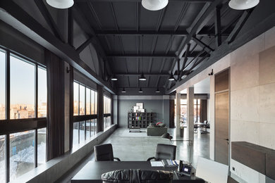 На фото: большое рабочее место в современном стиле с синими стенами, бетонным полом, отдельно стоящим рабочим столом и серым полом