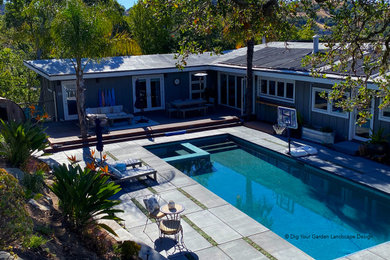 Ejemplo de piscina natural contemporánea extra grande rectangular en patio trasero con paisajismo de piscina y losas de hormigón