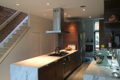 Enclosed kitchen - large eclectic galley limestone floor enclosed kitchen idea in DC Metro with an undermount sink, flat-panel cabinets, dark wood cabinets, marble countertops, stainless steel appliances, a peninsula, gray backsplash and stone tile backsplash