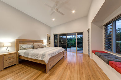 Photo of a modern guest bedroom in Sunshine Coast with white walls and light hardwood floors.