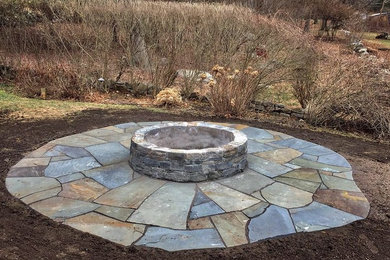 This is an example of a garden in Other with a fire feature and natural stone paving.