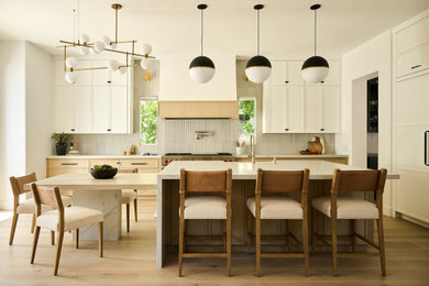 Large transitional light wood floor and beige floor kitchen photo in Orange County with a farmhouse sink, shaker cabinets, light wood cabinets, quartzite countertops, beige backsplash, ceramic backsplash, stainless steel appliances, an island and gray countertops